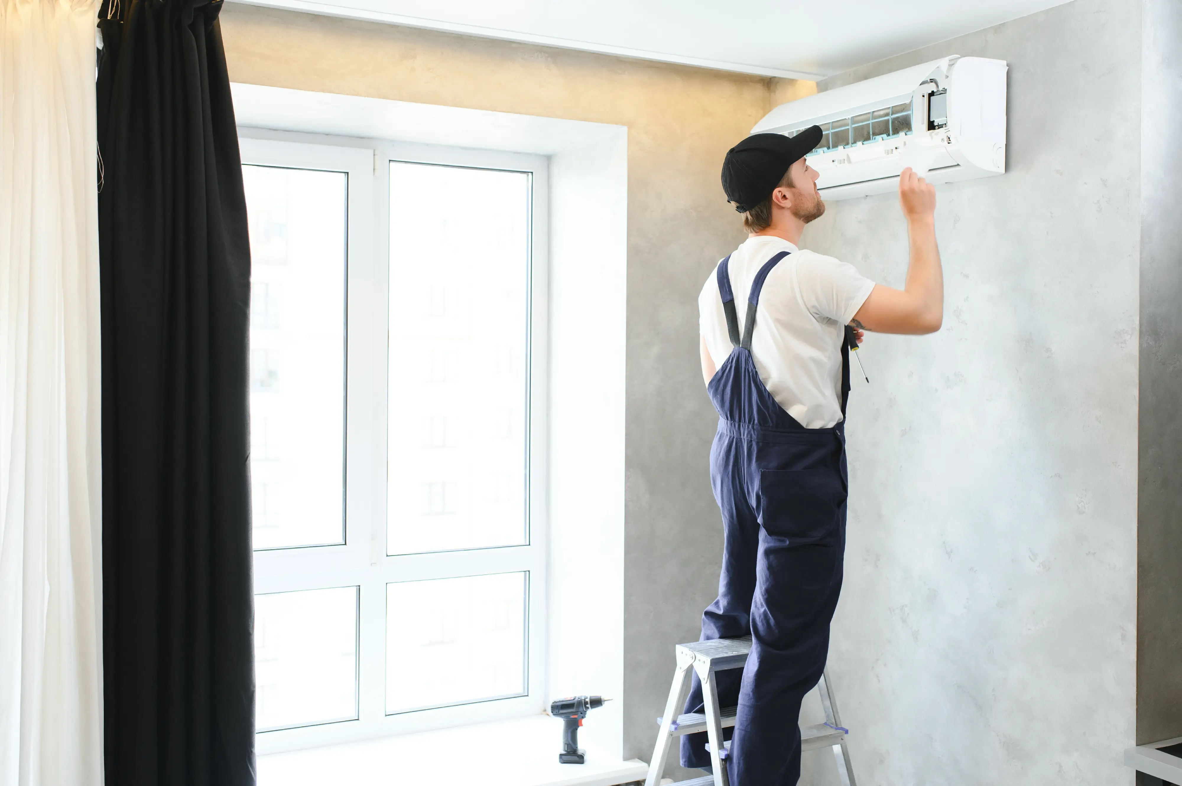 happy-male-technician-repairing-air-conditioner-2026-01-09-08-15-58-utc.webp