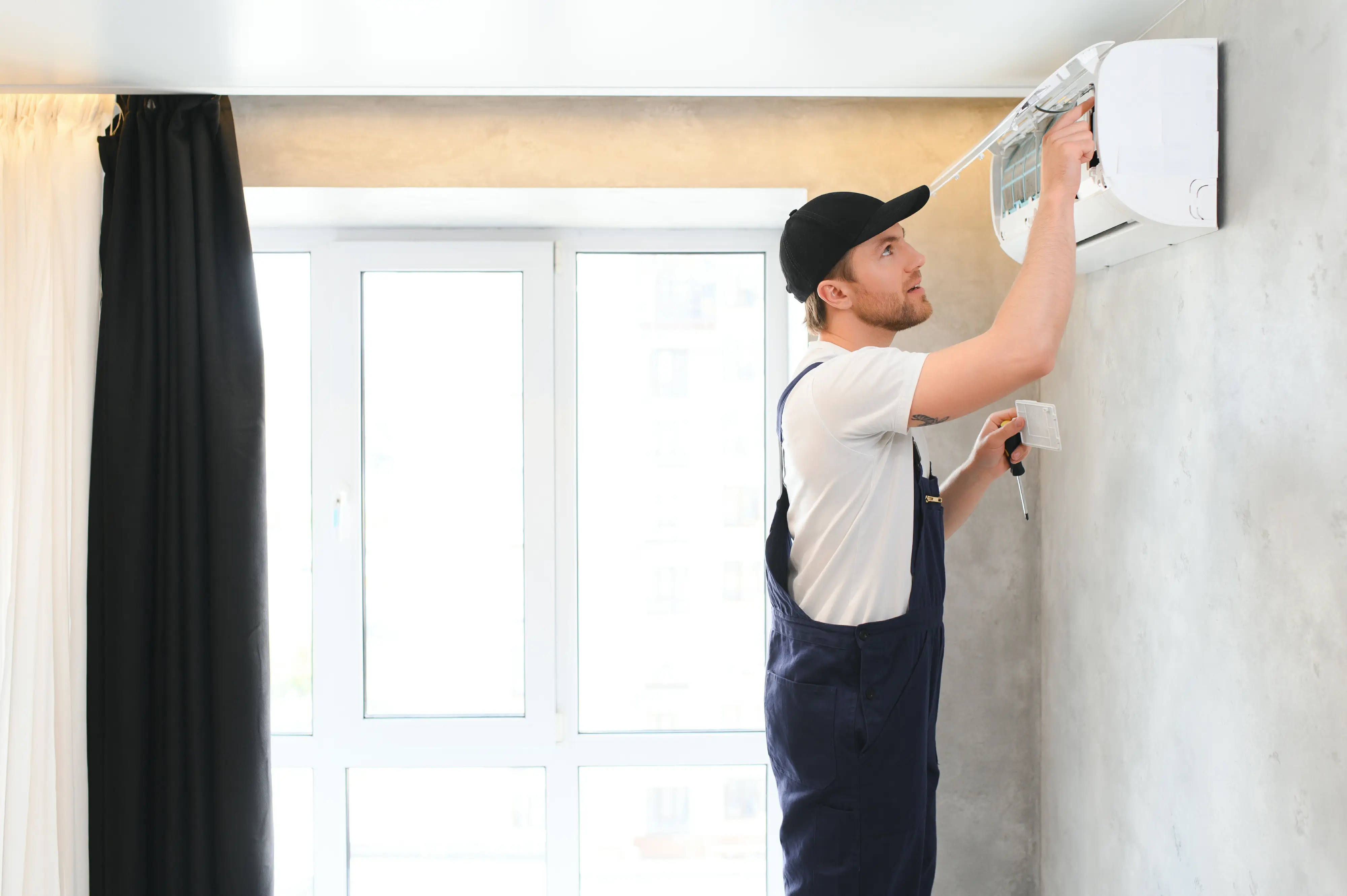 smiling-young-male-electrician-repair-conditioner-2026-01-09-06-41-34-utc.webp